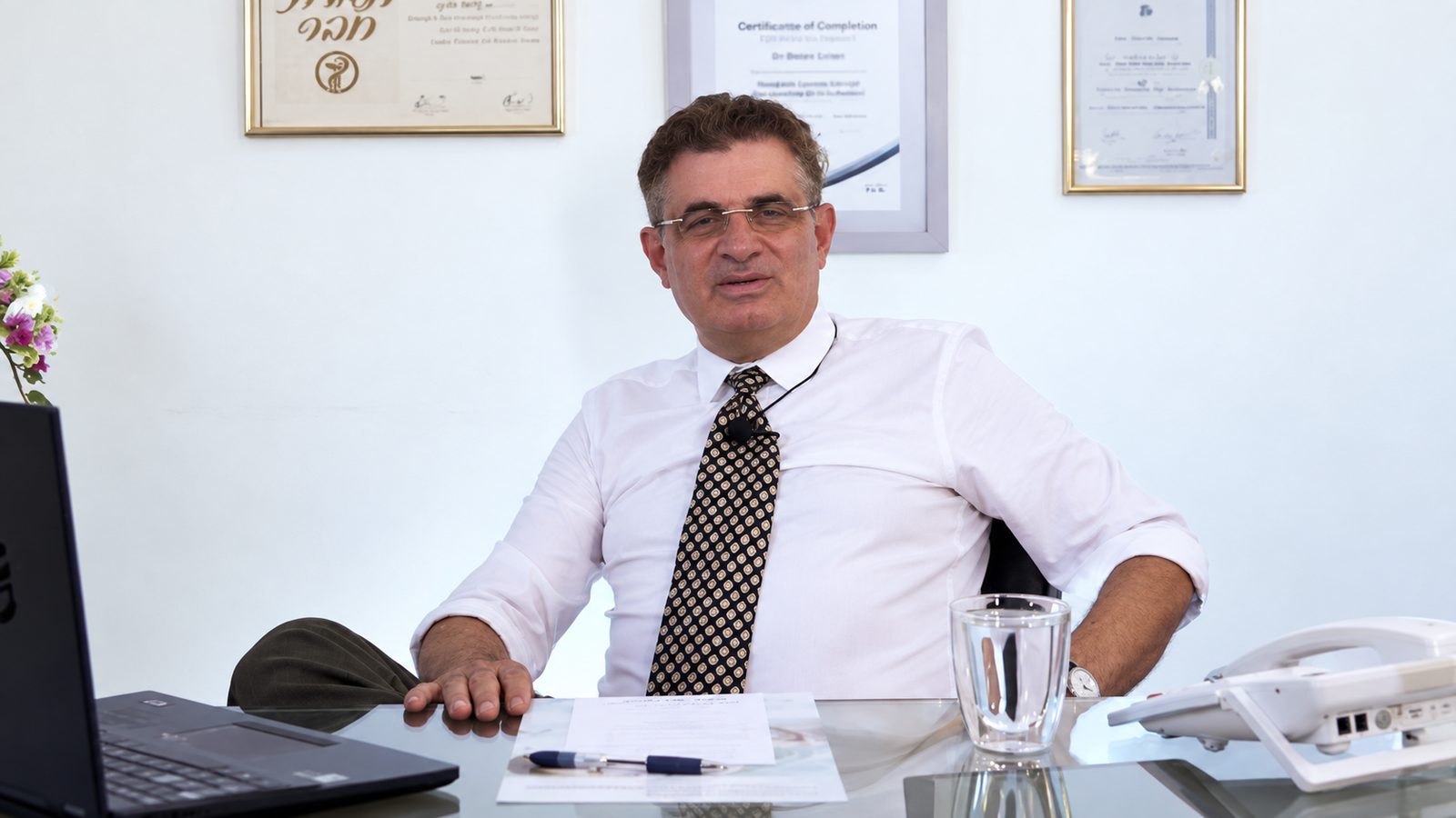 Д-р Дорон Котер в своём кабинете, на стене — дипломы и сертификаты